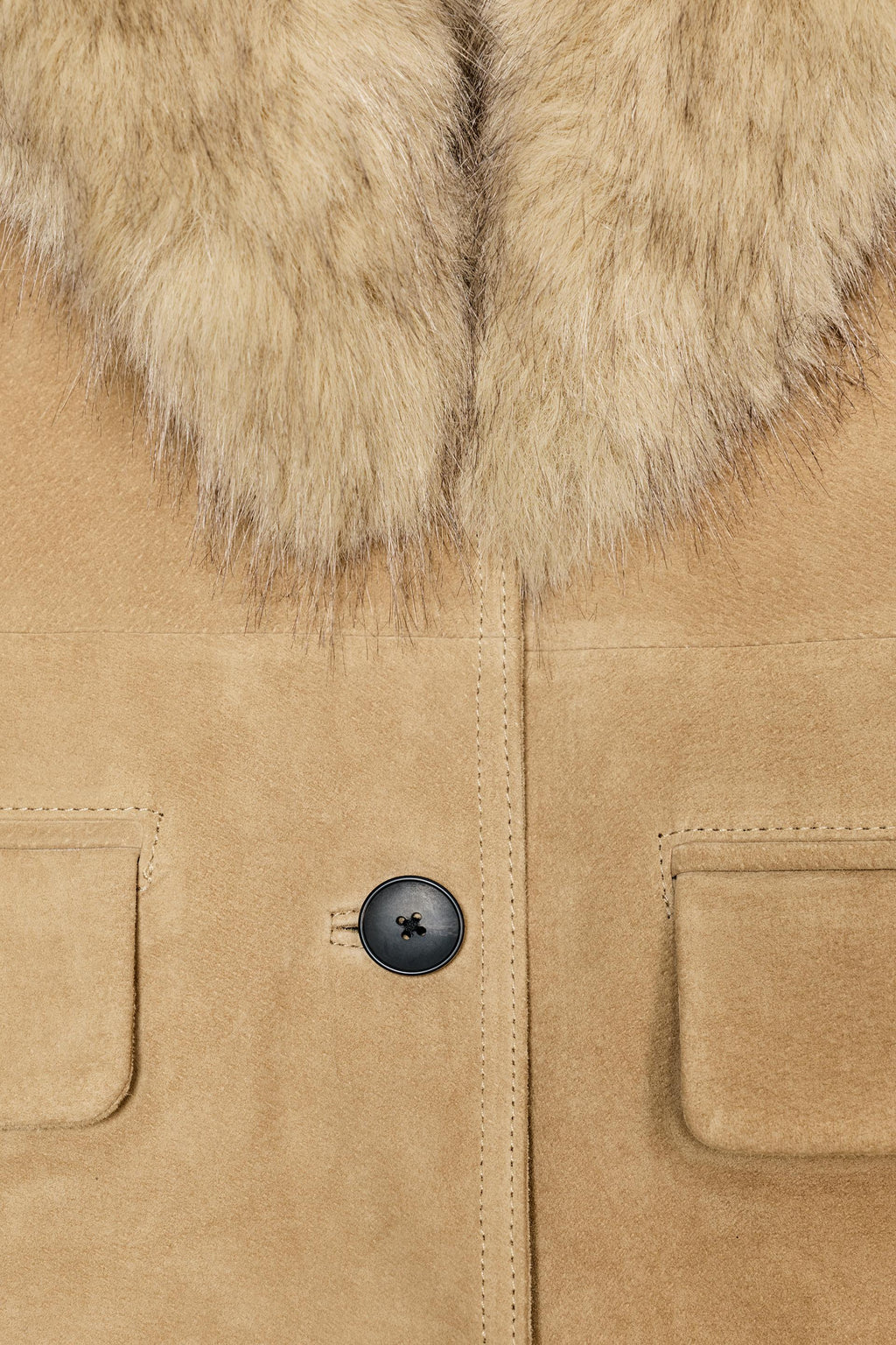 Close-up of a tan coat with fur collar and black button