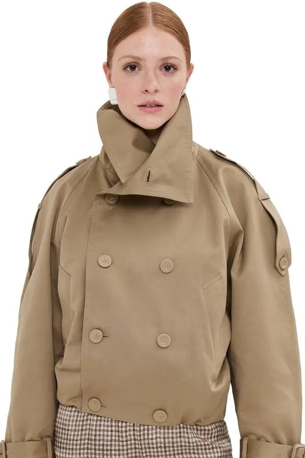 Person wearing a beige trench coat with a white background