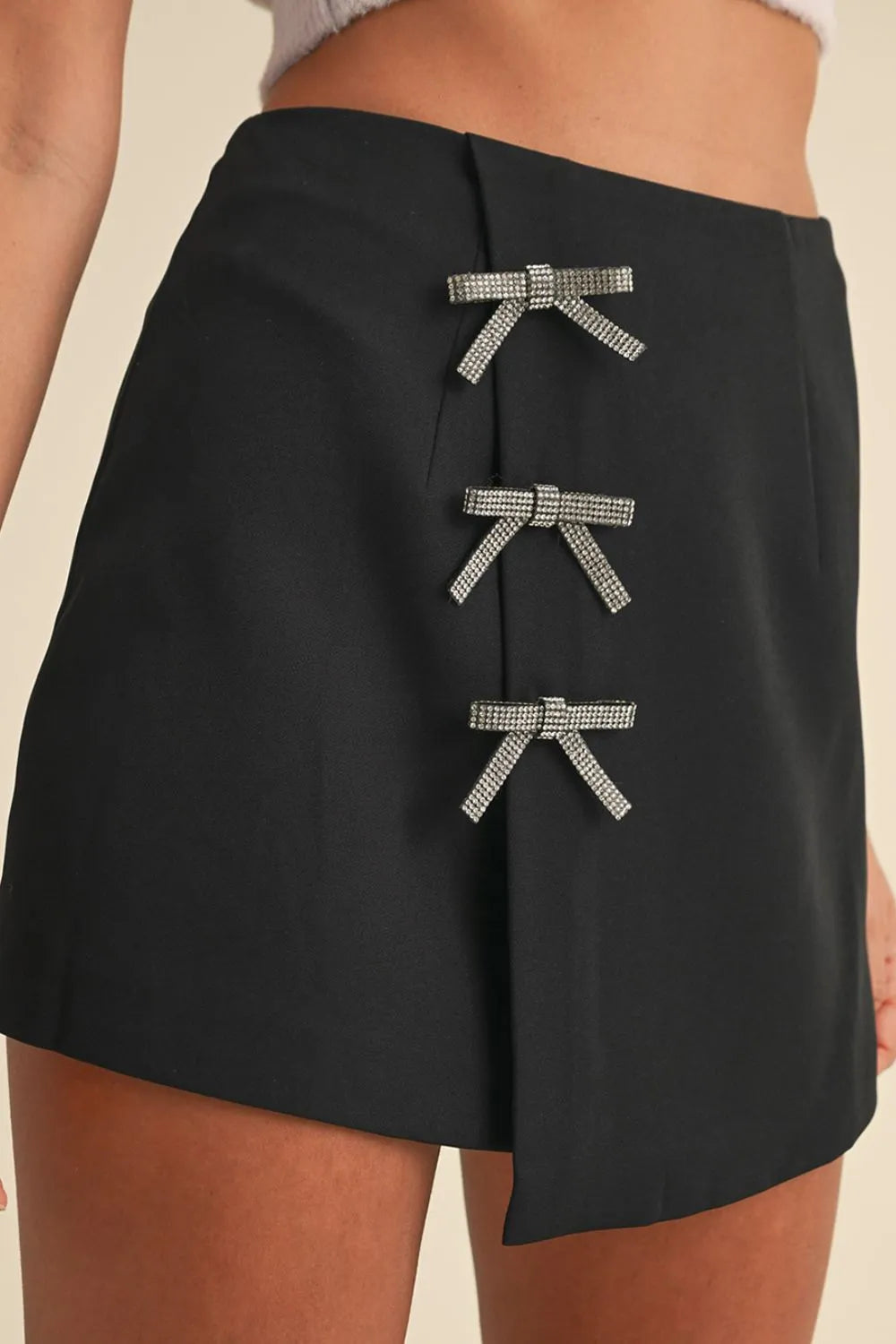 Black skirt with decorative bows on a beige background